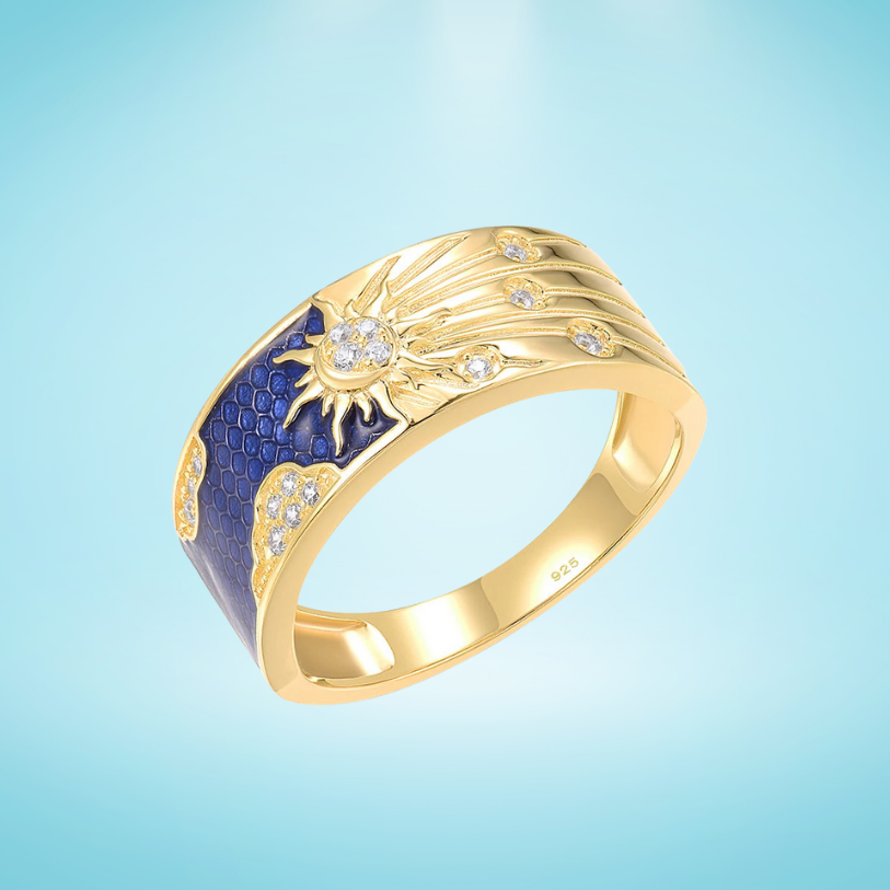 Gold-plated silver ring with a radiant sunburst design, sparkling stones, and deep blue enamel detailing