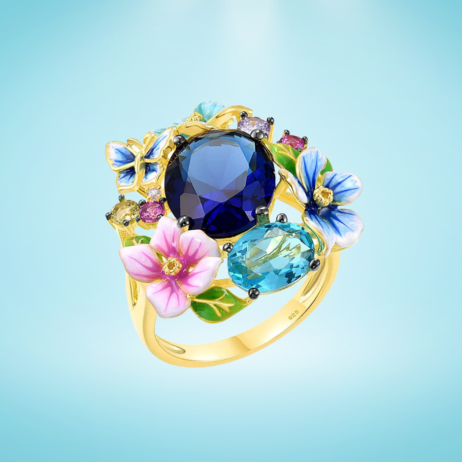 Gold-plated ring with a vibrant cluster of multicoloured enamel flowers, butterflies, and deep blue and aqua gemstones