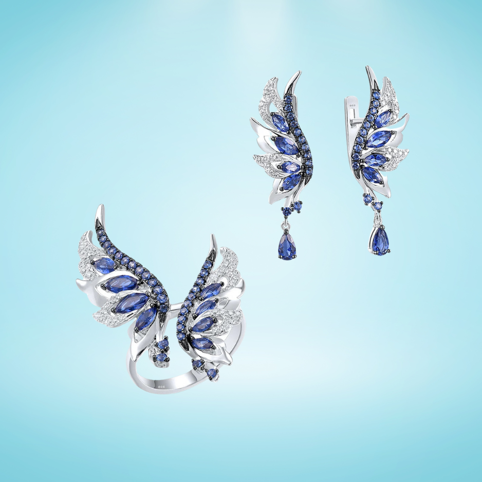 Matching silver ring and earrings set shaped like angel wings with blue and white stones in layered design