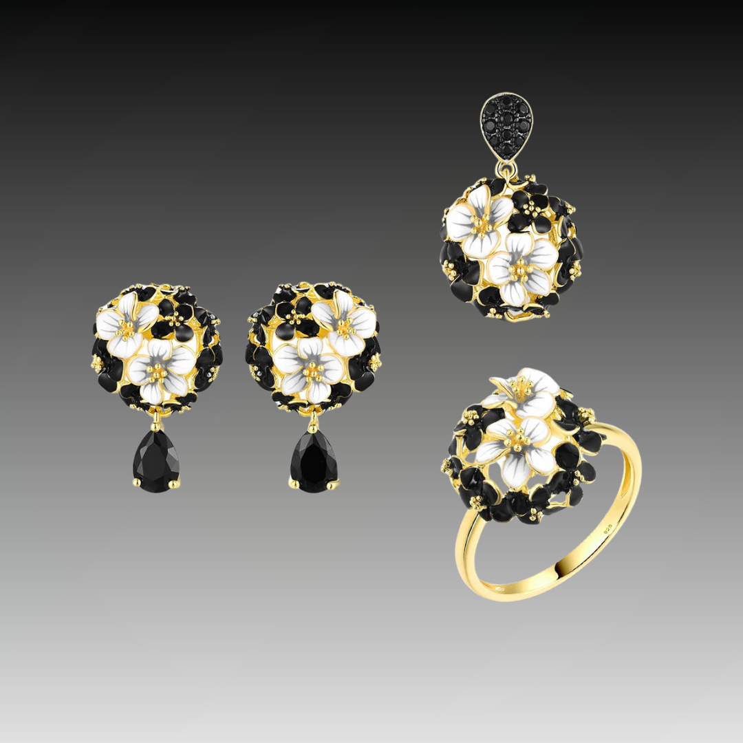 Matching jewelry set featuring black and white floral designs with gold settings, including earrings, pendant, and ring, titled Jacobaeus.