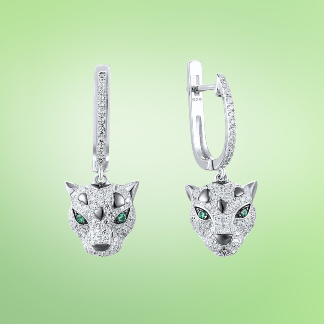 Silver drop earrings featuring panther heads with green gemstone eyes and pavé detail