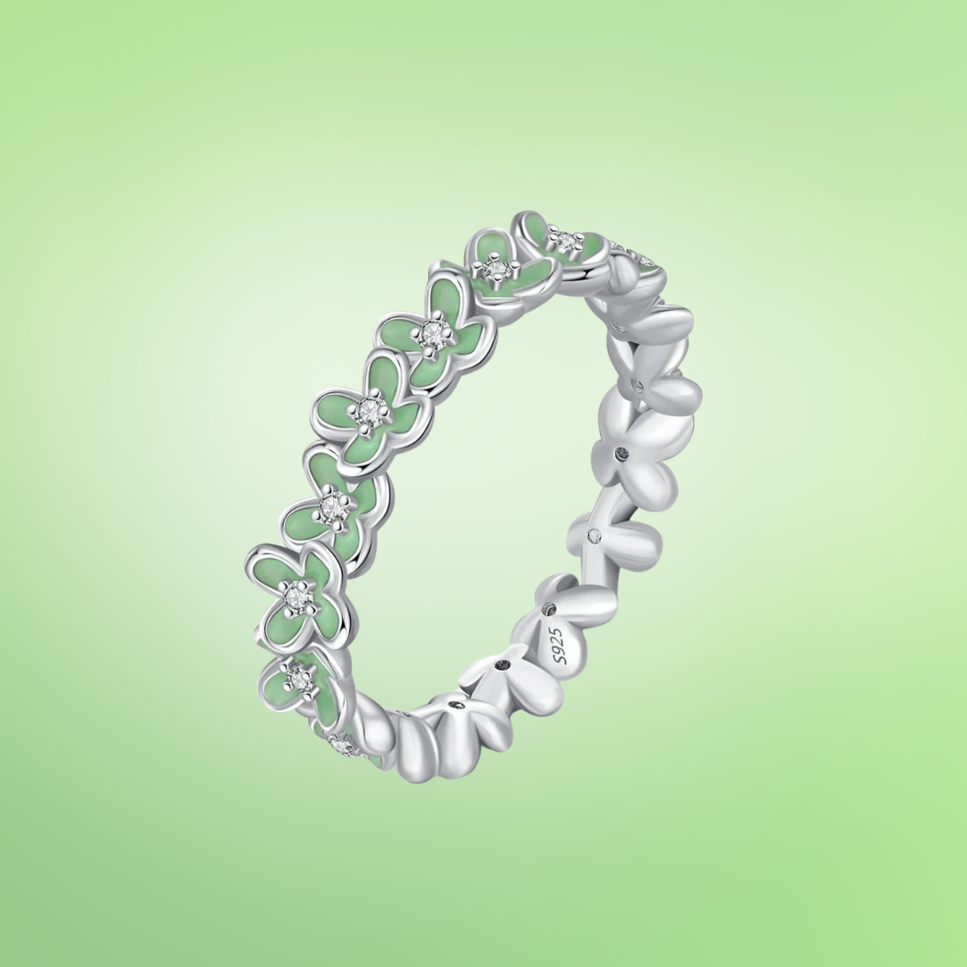 Sterling silver floral band ring with light green enamel petals and tiny diamond accents.