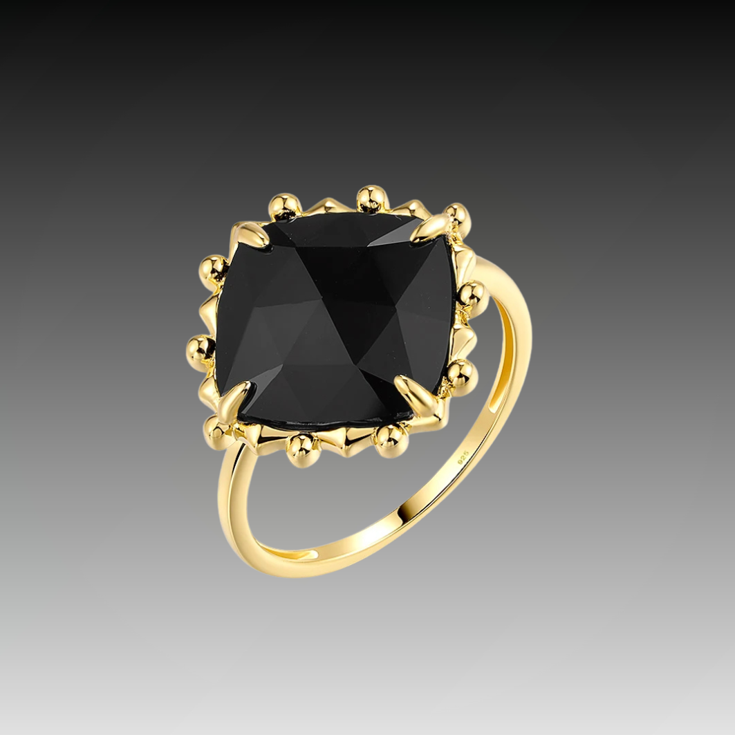 Gold ring with a large cushion-cut black stone and decorative claw prongs.