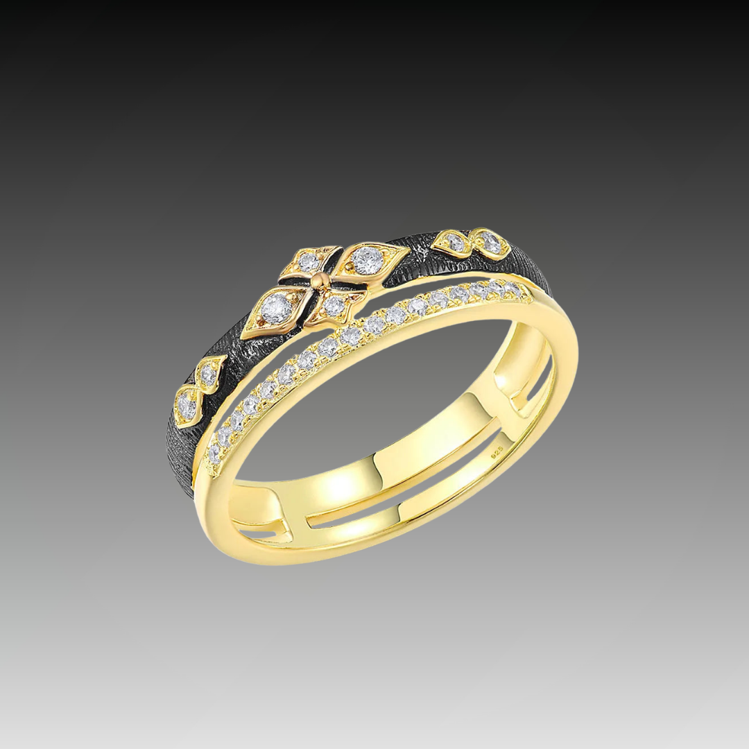 Gold ring with diamond accents and a contrasting textured black band featuring a geometric floral design.