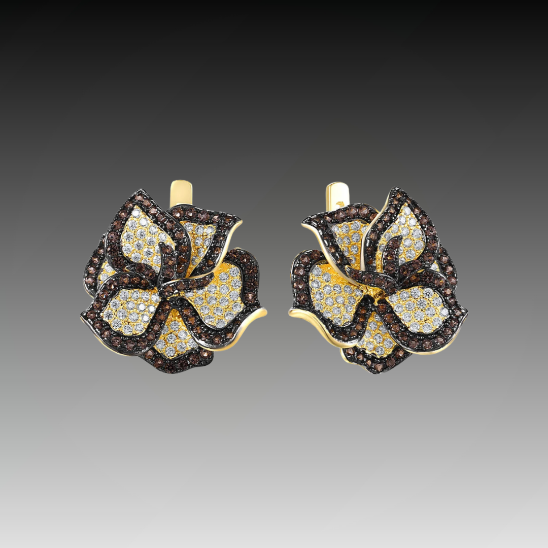Gold earrings shaped like trillium flowers, paved with white and brown gemstones.
