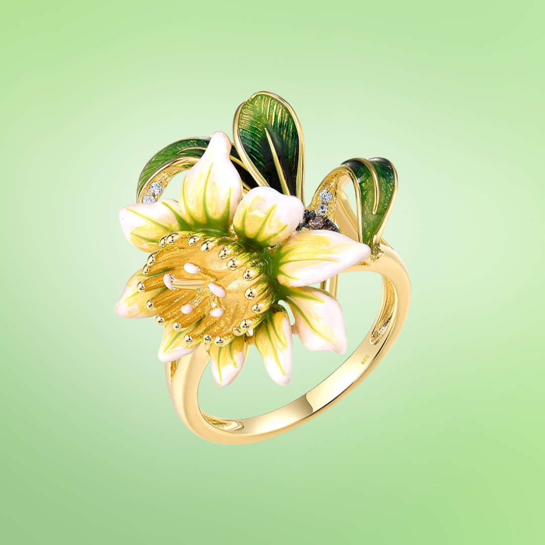 Gold ring with detailed yellow and white enamel flower, green enamel leaves, and subtle crystal accents