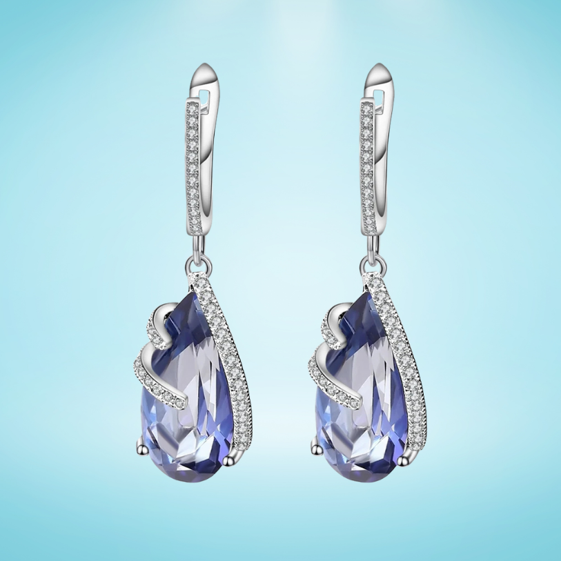 Silver earrings with faceted blue teardrop stones and delicate pavé accents