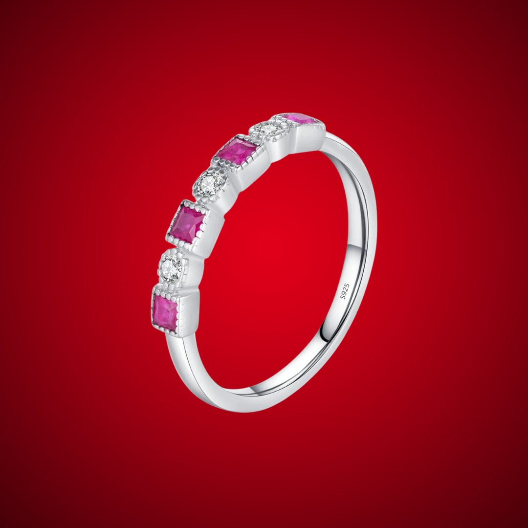 Sterling silver ring with alternating square-cut red stones and round clear stones in a linear setting.