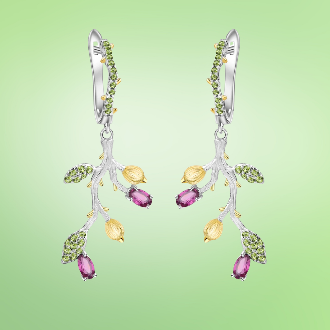 Silver branch-inspired earrings with green leaves and purple gemstone drops