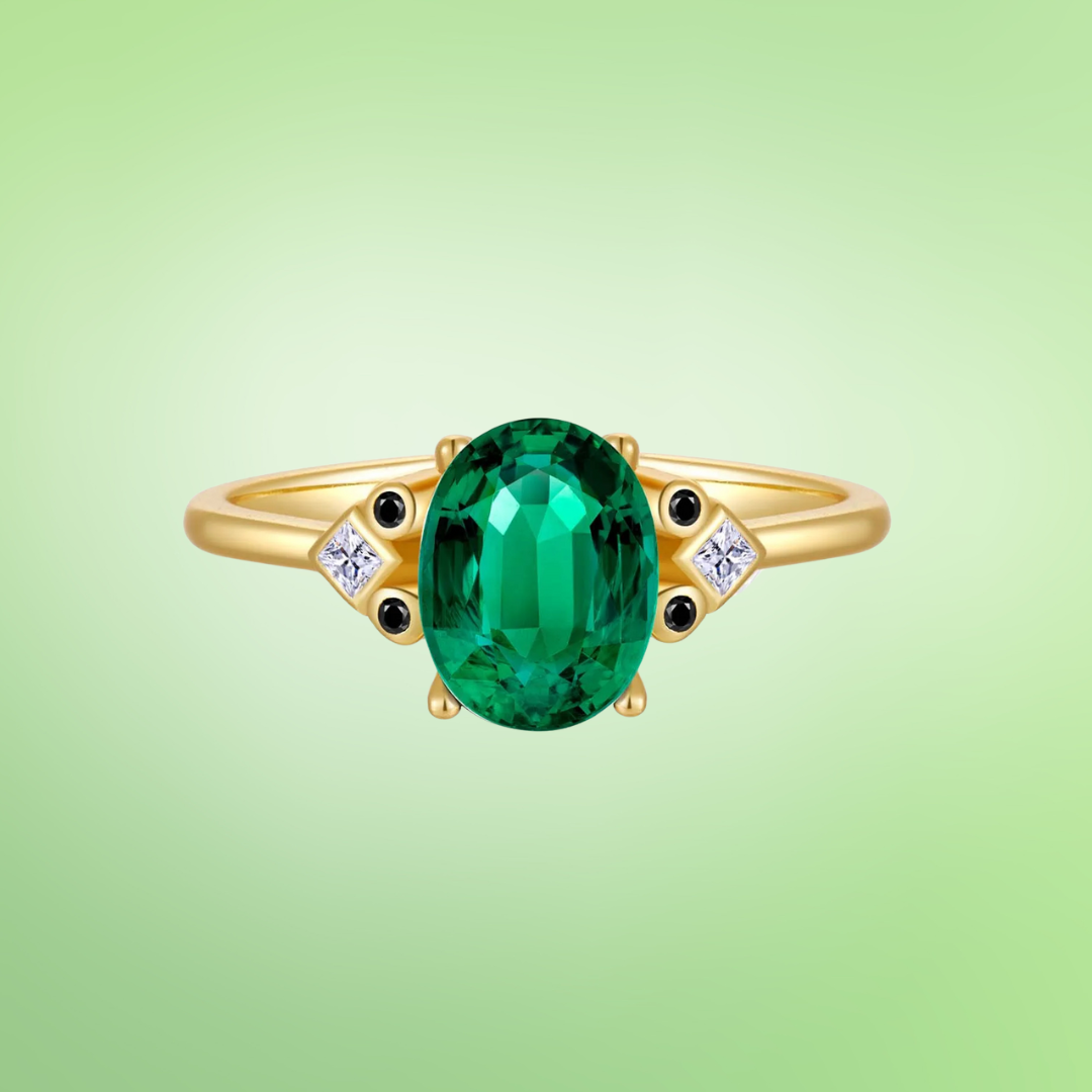 Gold ring with large oval green stone, flanked by small black and white accent stones