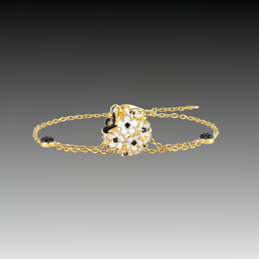 Gold bracelet featuring a cluster of white enamel flowers with black stone centers, from the Fiore Scuro line.