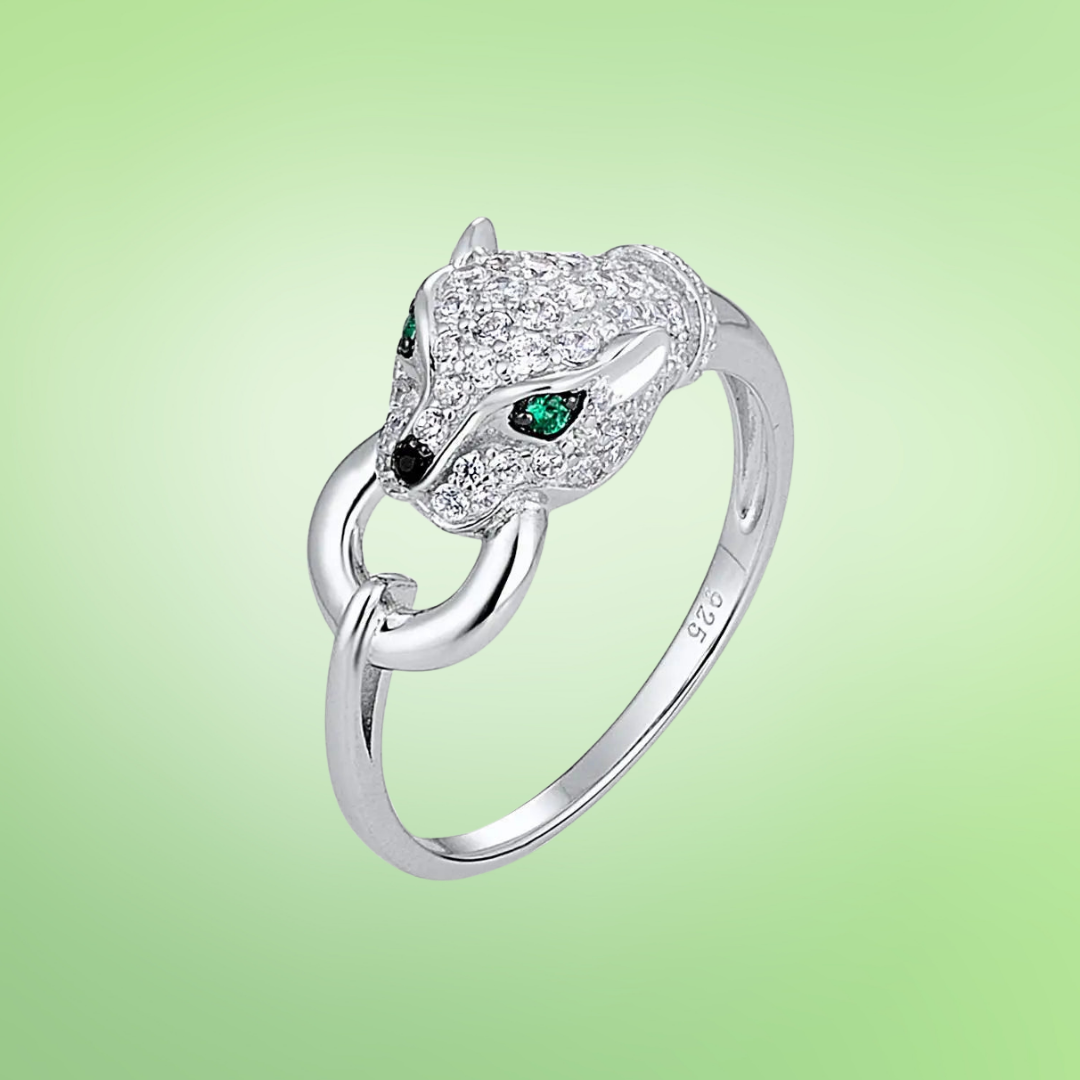 Silver ring featuring a panther head with green gemstone eyes and pavé detailing