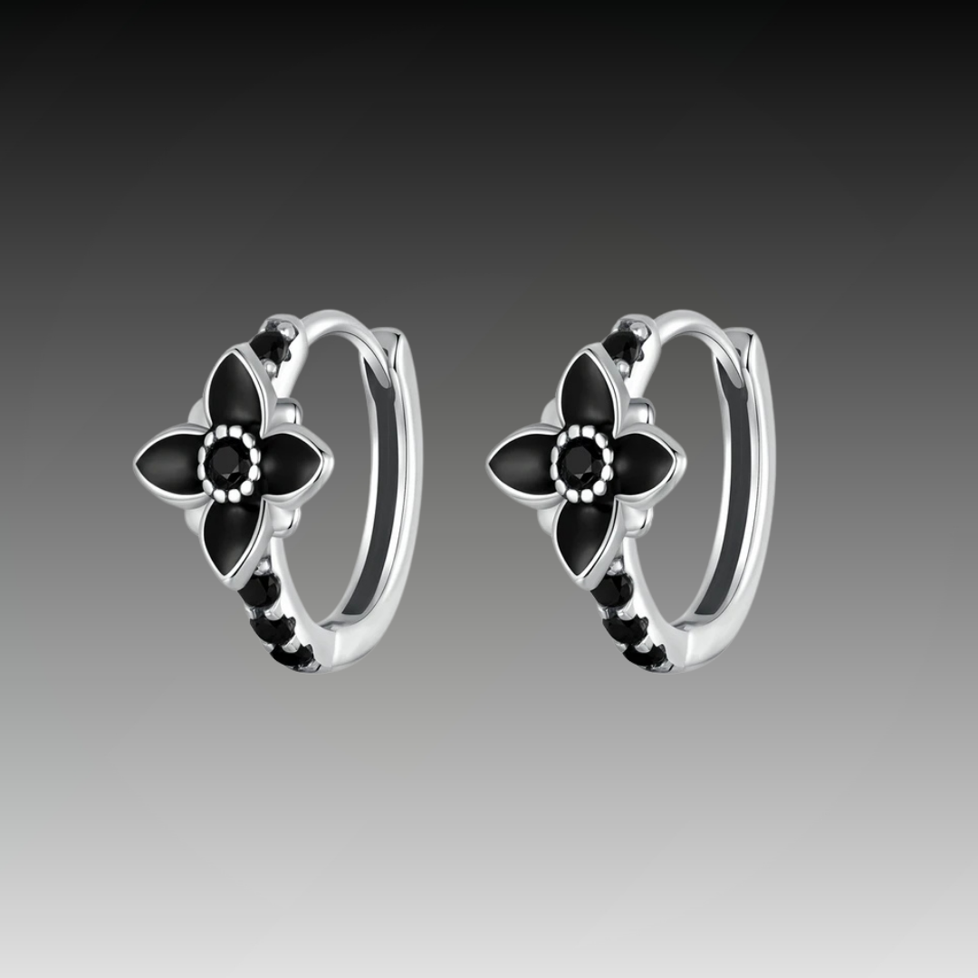 Pair of silver hoop earrings featuring black enamel flowers and black stones, from the Bianco Nero collection.
