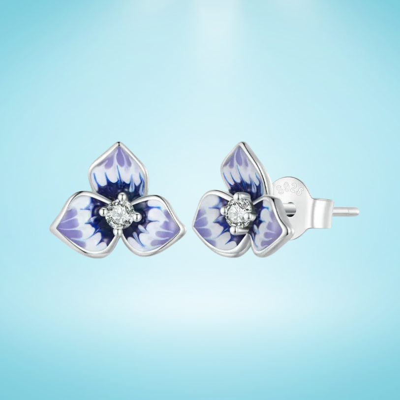 Sterling silver stud earrings shaped like purple enamel orchid flowers with a clear round gemstone at the center