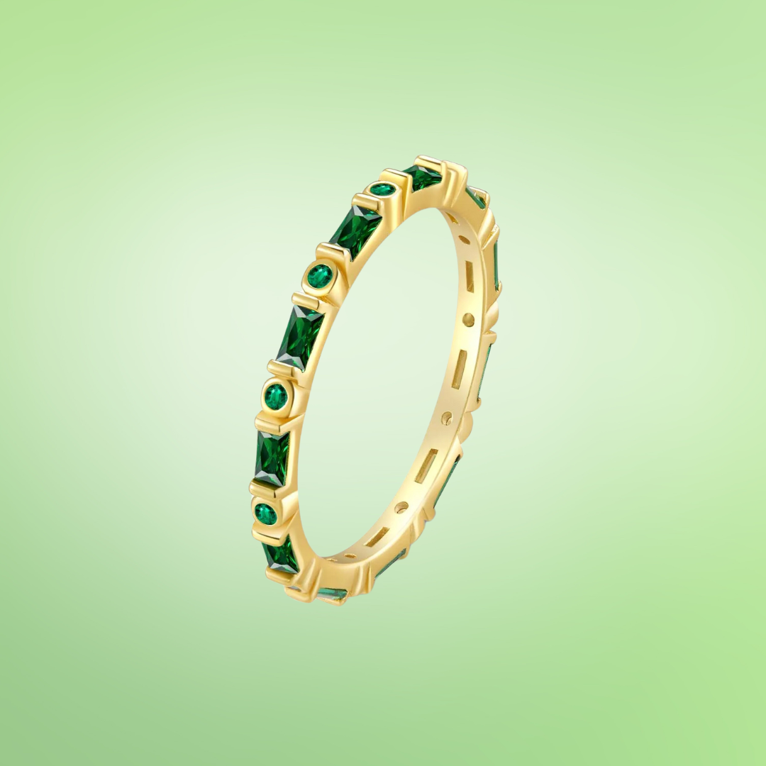 Gold eternity band with alternating round and baguette green stones