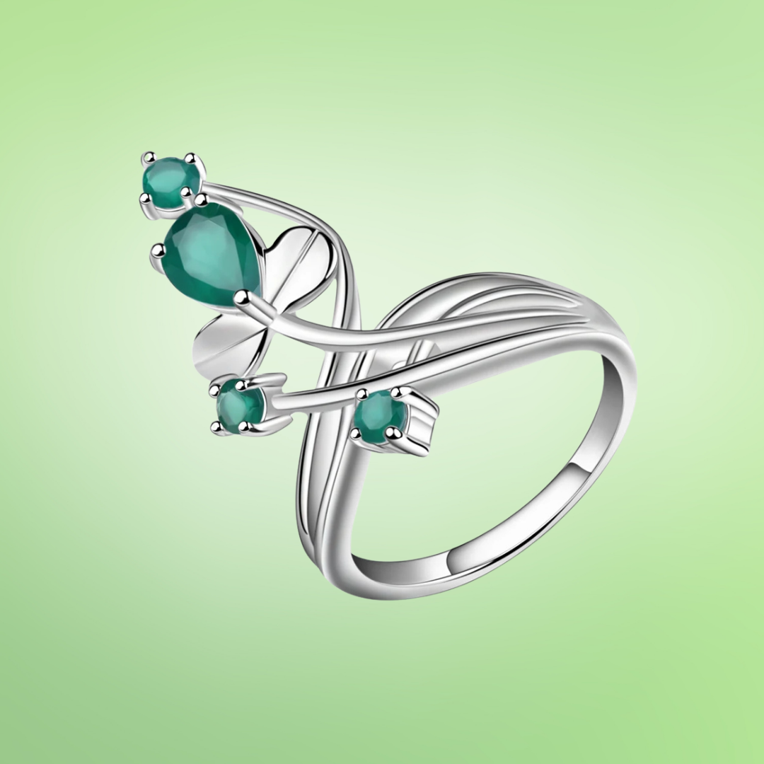Open silver ring with four green stones arranged like petals on curved stems