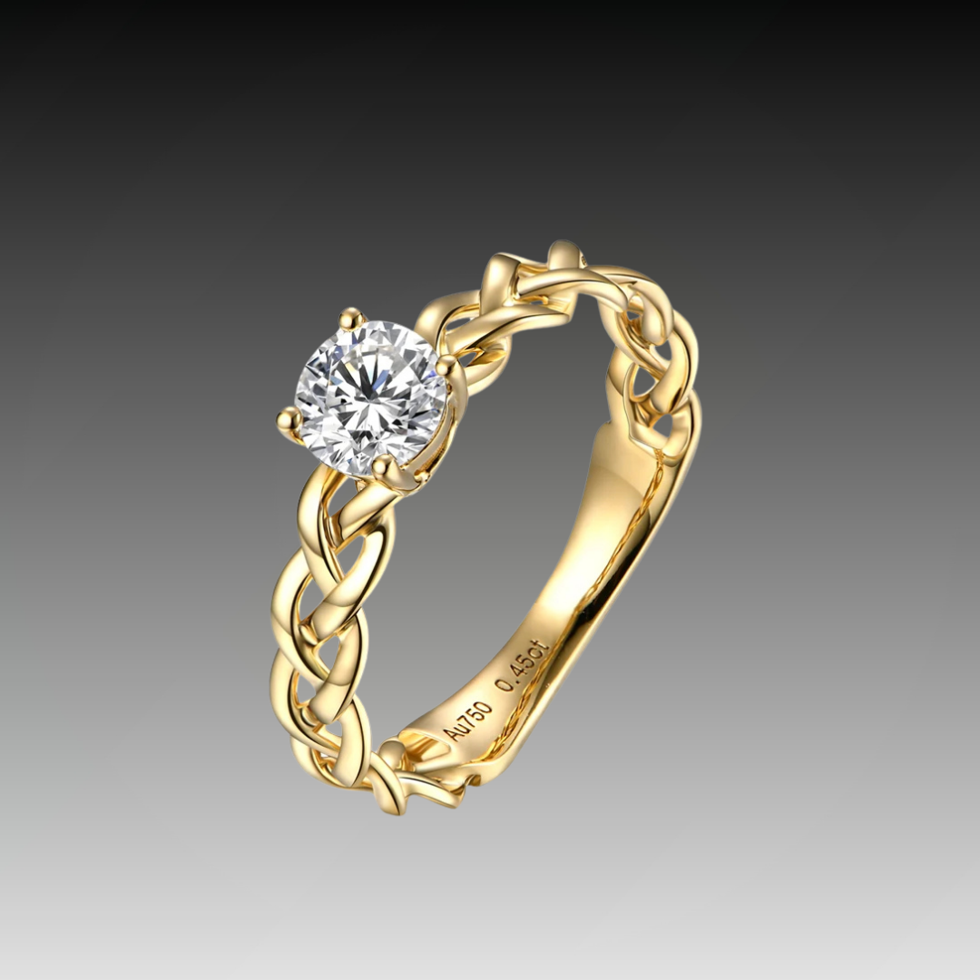 Gold ring with a braided band design and a round-cut clear central stone in a four-prong setting.