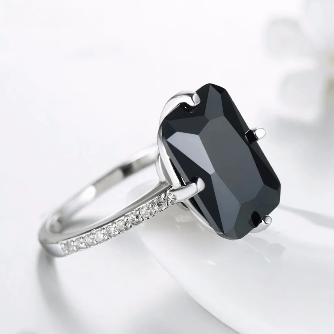 Silver ring with a large faceted black stone and pavé band