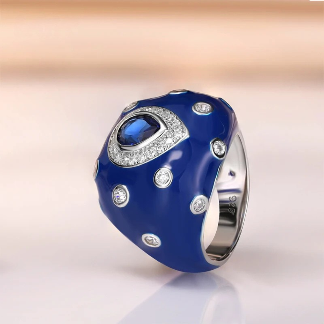 Sterling silver ring with a domed cobalt blue enamel surface, featuring a central teardrop blue gemstone and scattered clear crystals