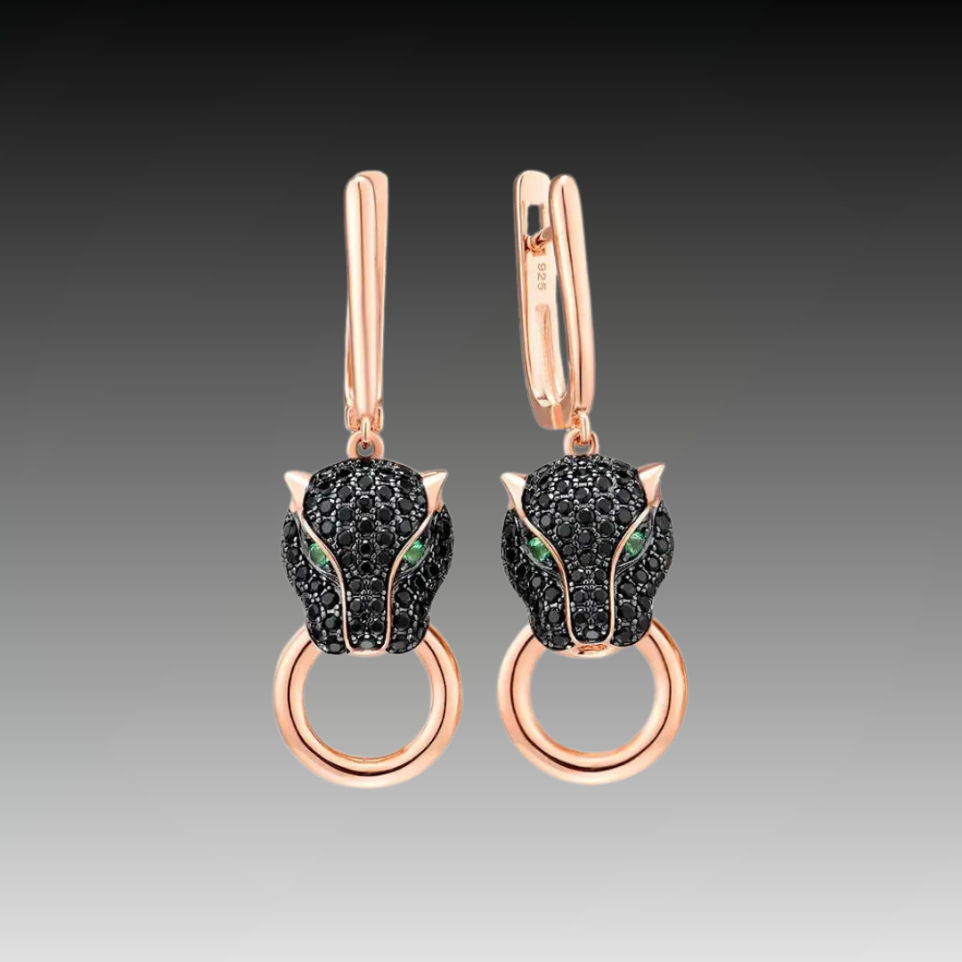 Rose gold earrings featuring black panther heads with green gemstone eyes and ring details.