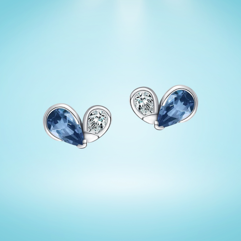 Silver heart-shaped earrings with deep blue gemstones and pavé accents