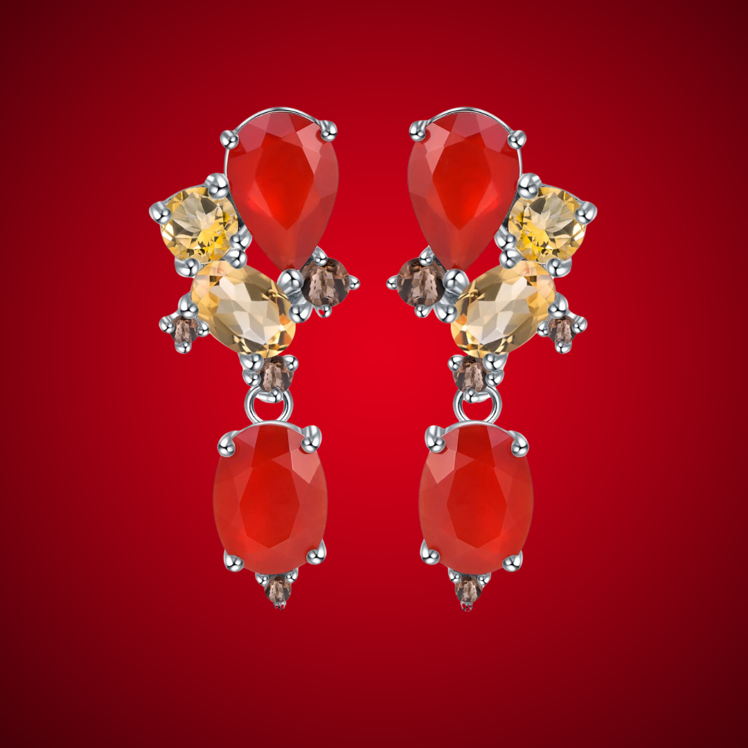 Drop earrings with a mix of red, amber, and brown faceted stones set in silver-toned prongs.