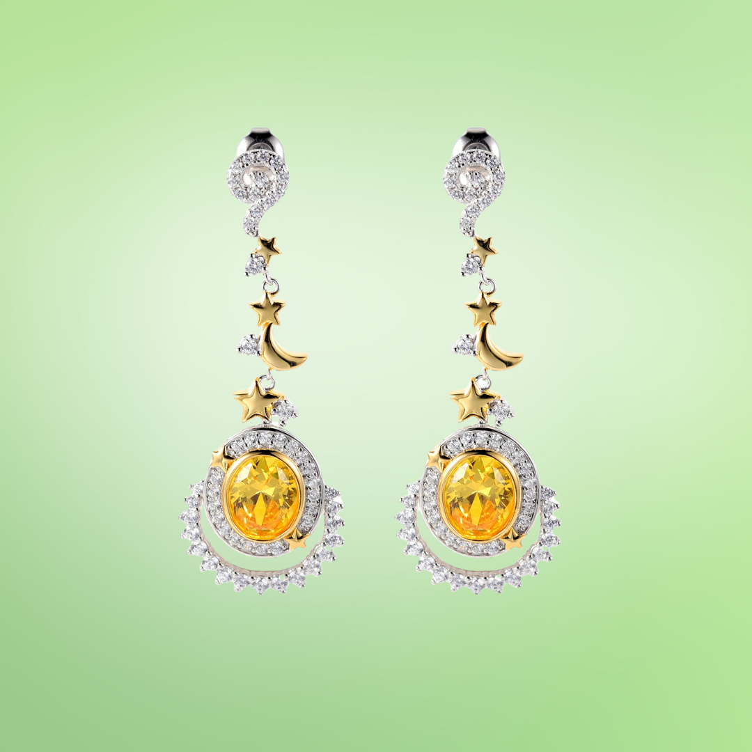 Dangling earrings with yellow gemstones, crescent moons, and star accents in gold and silver