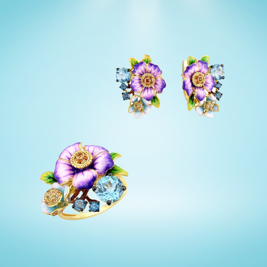 Colorful floral jewelry set featuring purple aquilegia flowers with green leaves, blue stones, and gold-tone detailing
