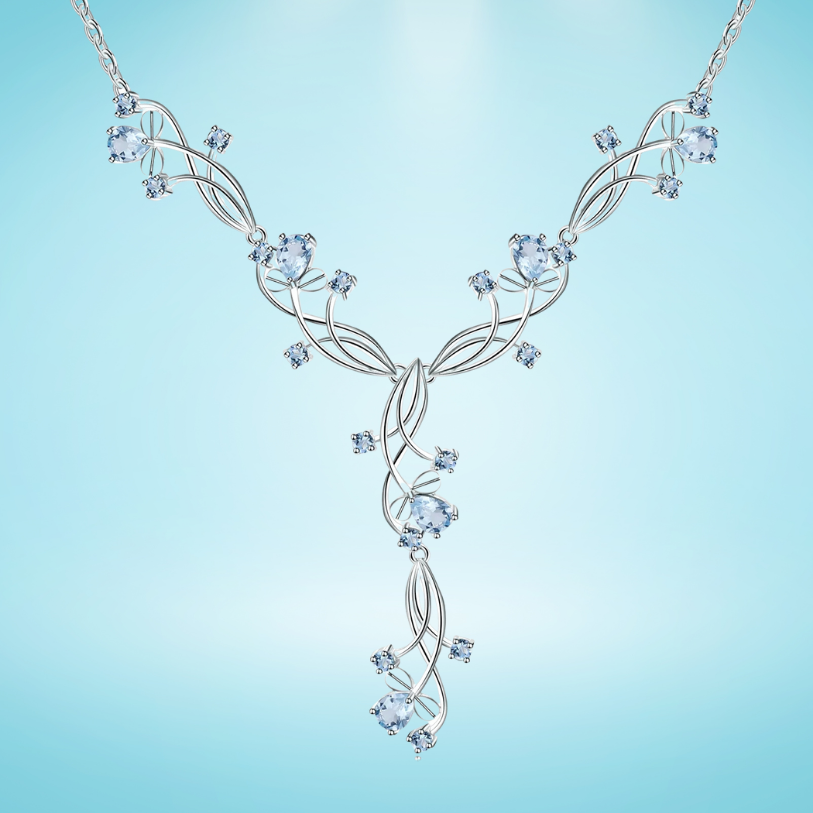 Sterling silver necklace with intertwining strands and scattered light blue gemstones forming a cascading floral design