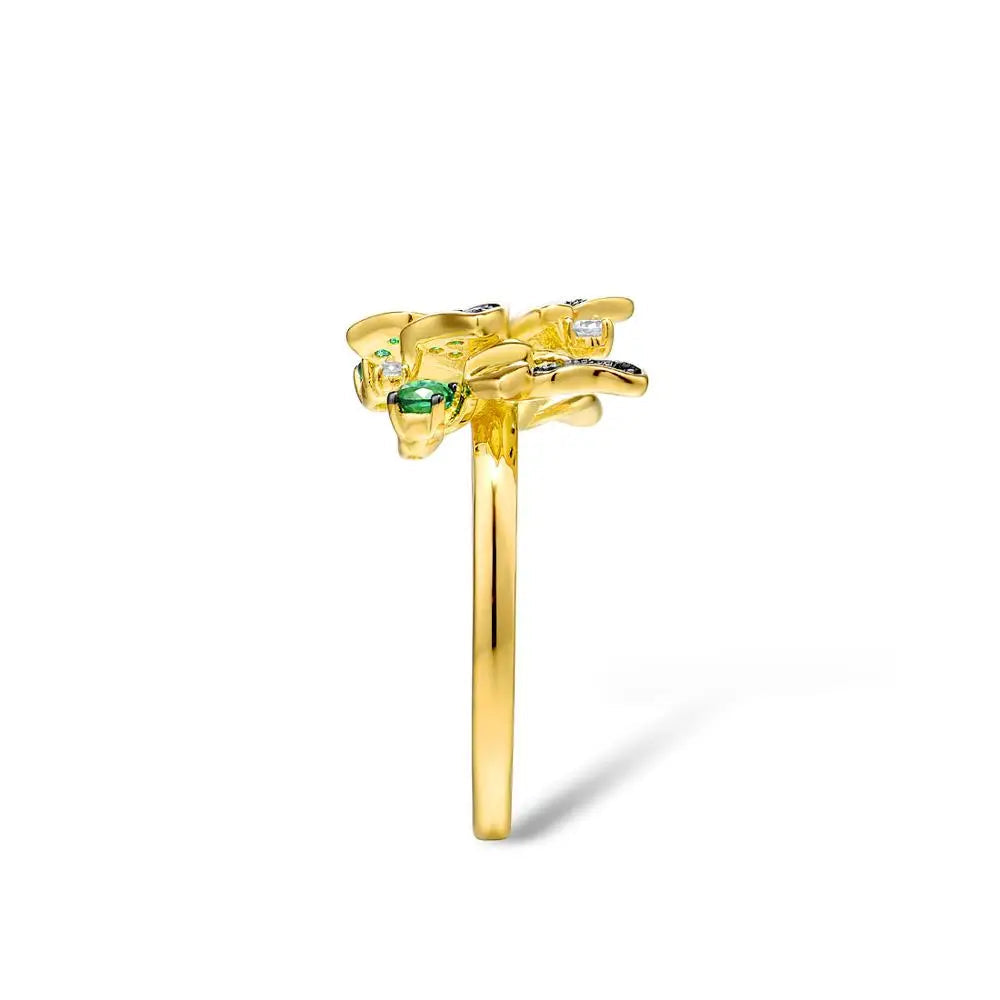 Gold butterfly ring adorned with green crystals and delicate flower accents