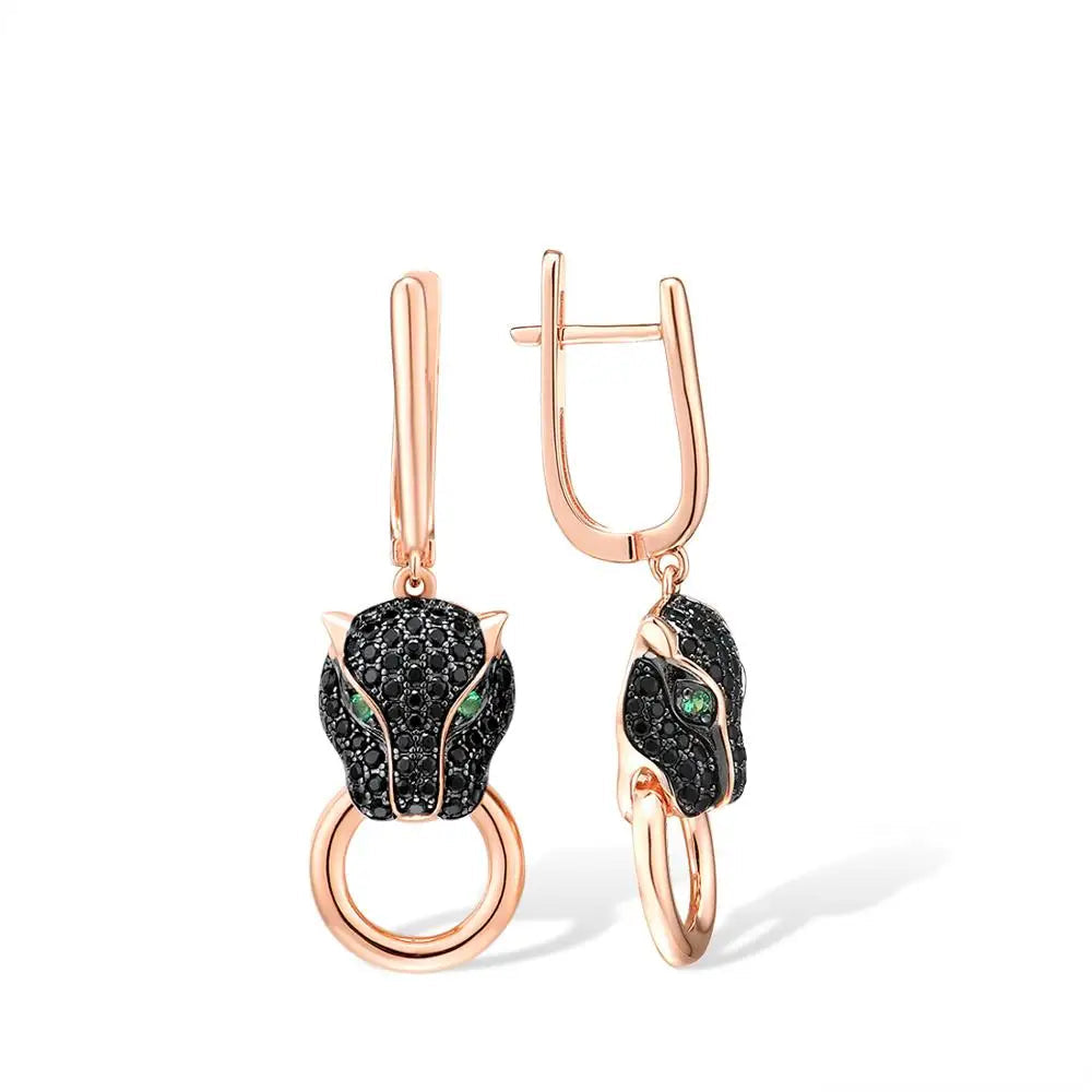 Rose gold earrings featuring black panther heads with green gemstone eyes and ring details.