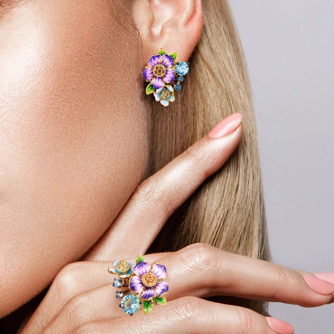 Colorful floral jewelry set featuring purple aquilegia flowers with green leaves, blue stones, and gold-tone detailing