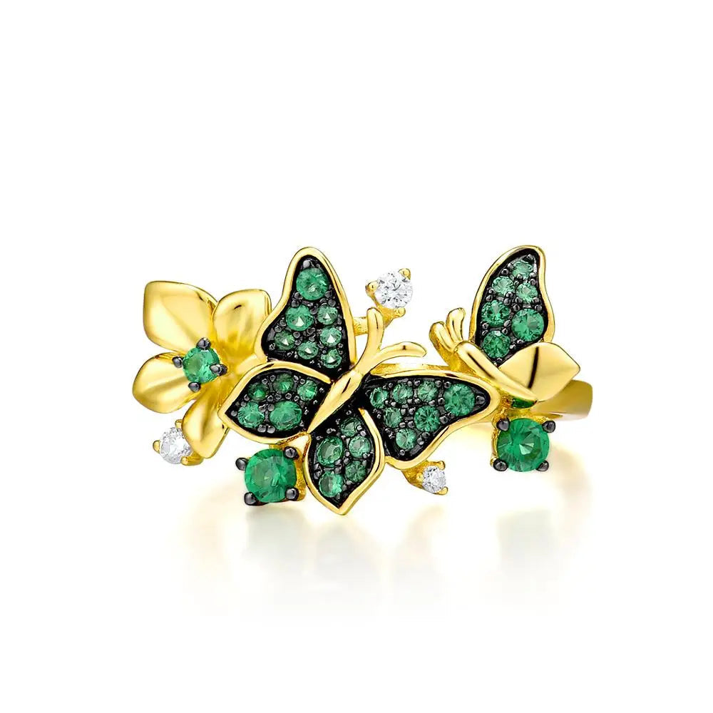 Gold butterfly ring adorned with green crystals and delicate flower accents