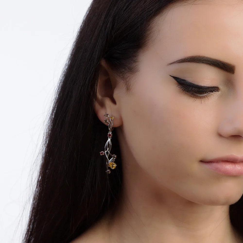 Pair of silver drop earrings with yellow teardrop stones and mixed round gemstones in pink, champagne, and yellow tones.