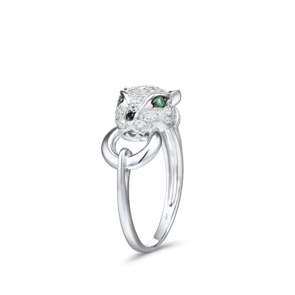 Silver ring featuring a panther head with green gemstone eyes and pavé detailing