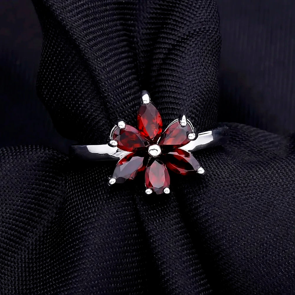 Silver ring featuring a flower design made of six marquise-cut deep garnet-red stones, from the Rossa Collection.