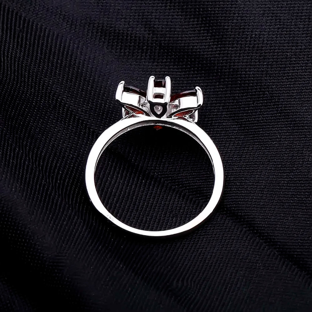 Silver ring featuring a flower design made of six marquise-cut deep garnet-red stones, from the Rossa Collection.