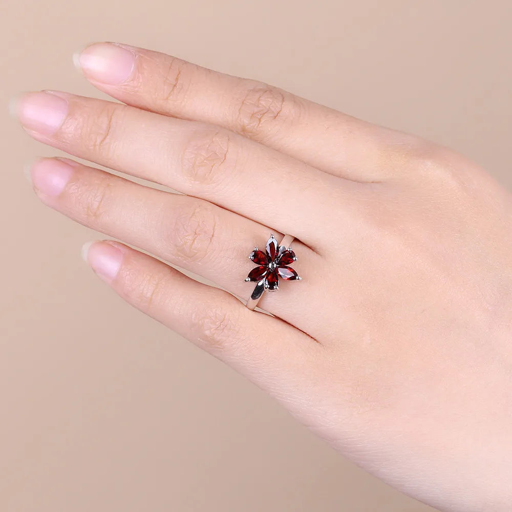 Silver ring featuring a flower design made of six marquise-cut deep garnet-red stones, from the Rossa Collection.