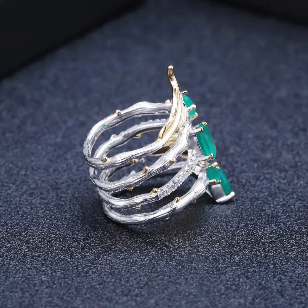 Multi-band silver ring with green gemstones, gold leaf accents, and intricate vine-like detailing