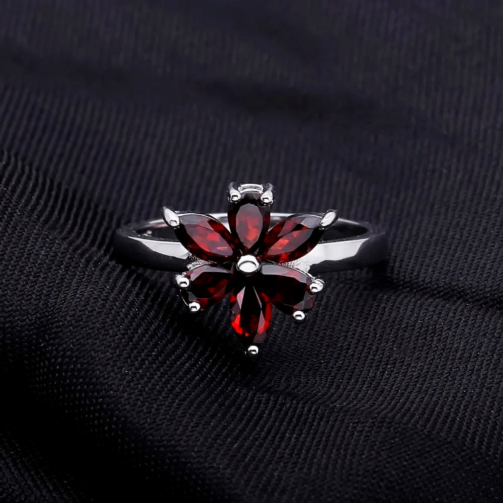 Silver ring featuring a flower design made of six marquise-cut deep garnet-red stones, from the Rossa Collection.