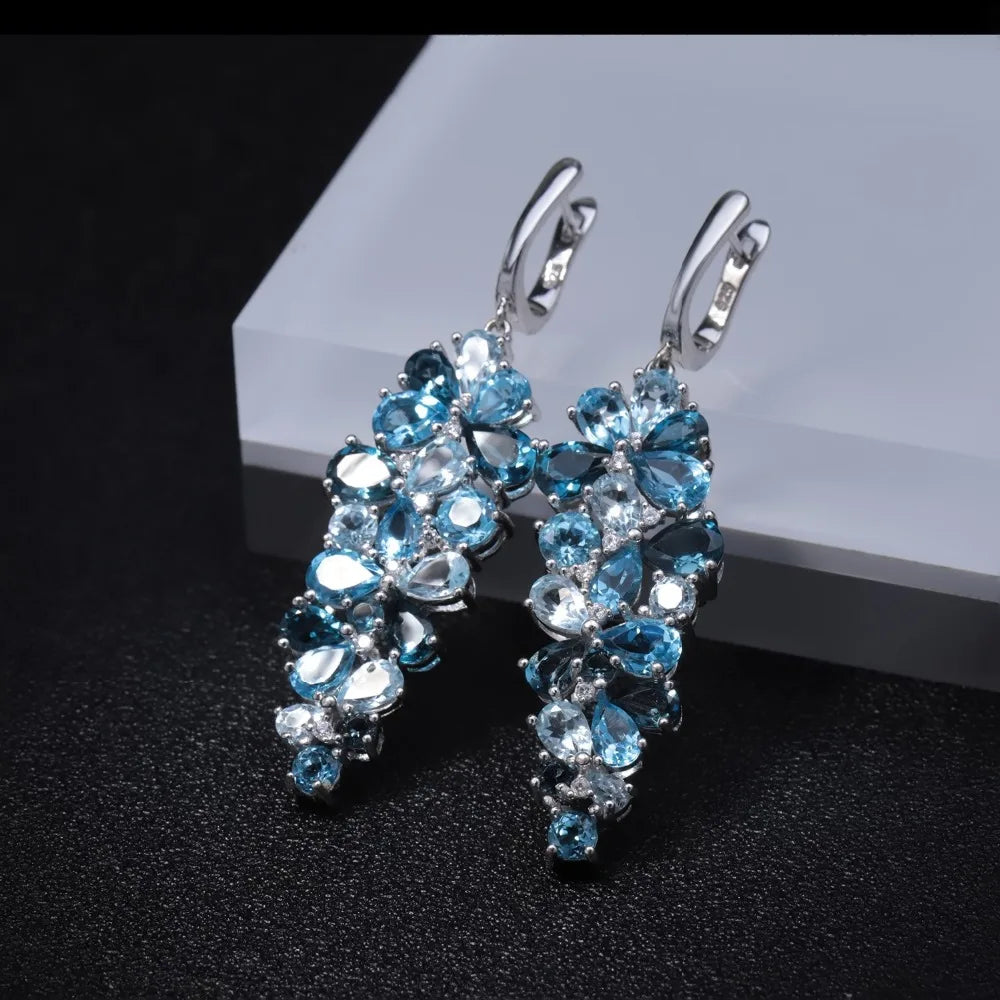 Silver drop earrings with clusters of marquise and pear-cut blue gemstones in varying shades