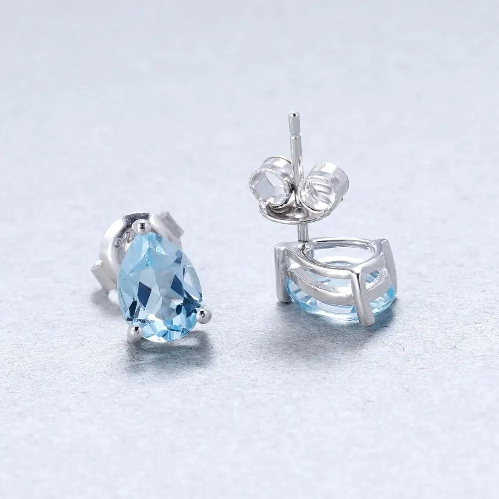 Sterling silver stud earrings with pear-shaped blue topaz gemstones in a three-prong setting