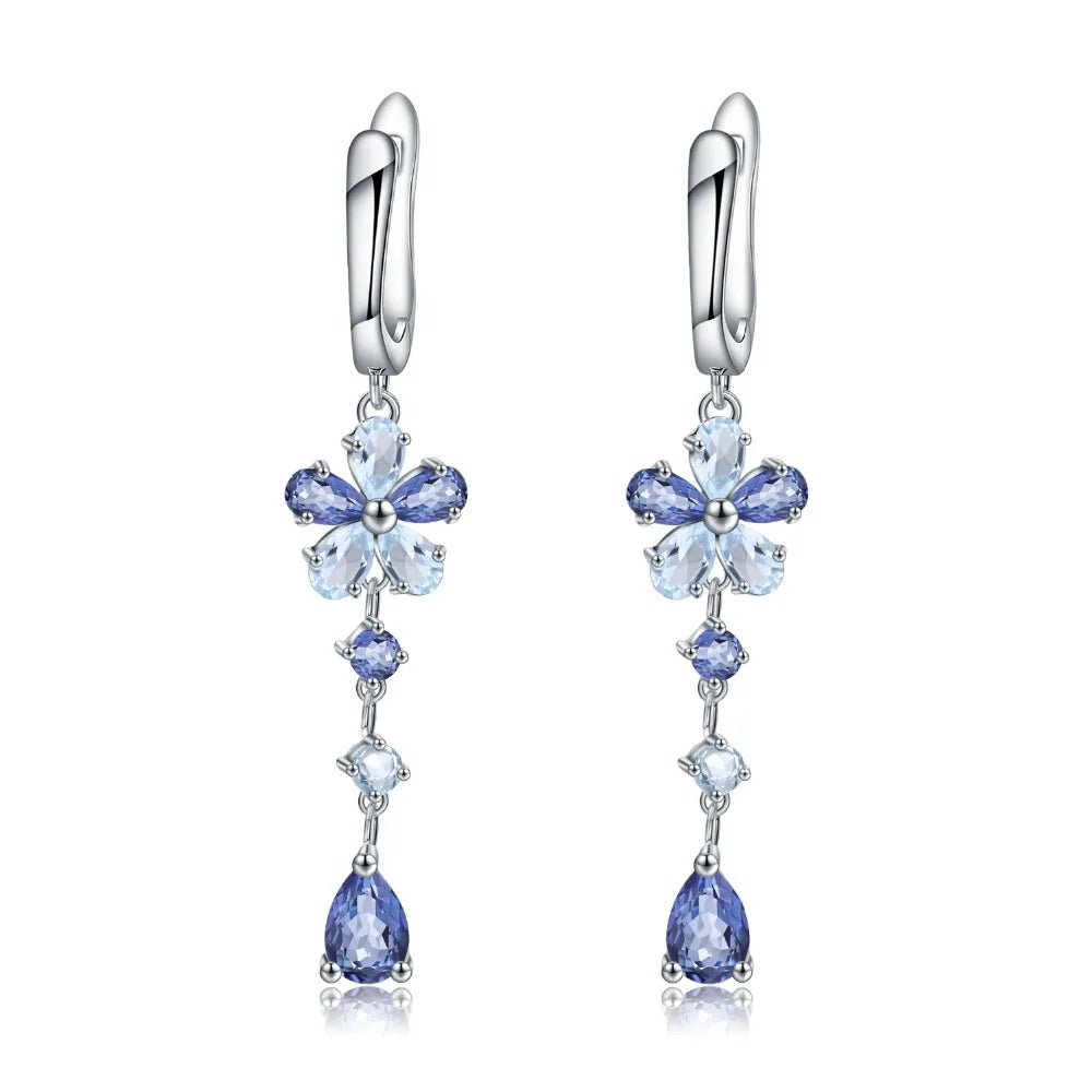 Drop earrings featuring floral blue gemstone clusters and pear-cut drops on a silver setting