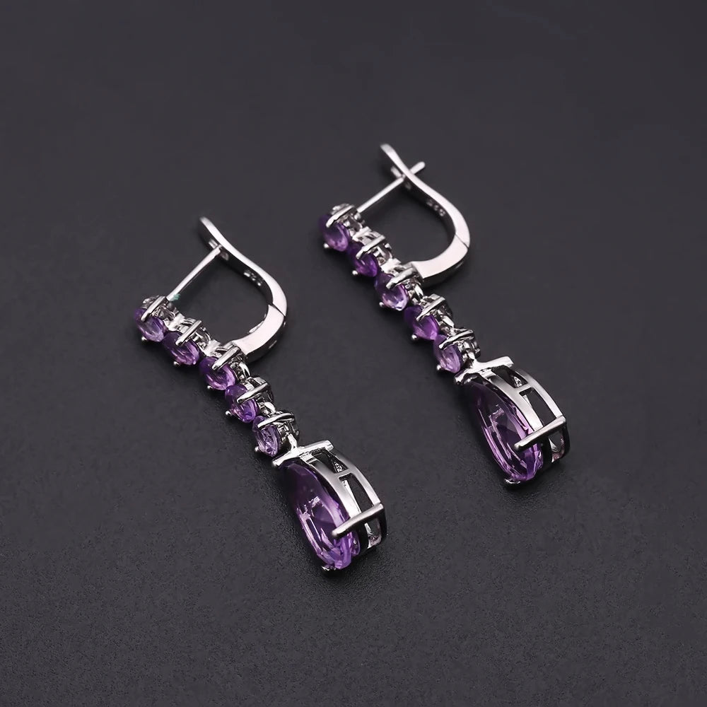 Sterling silver drop earrings with a vertical line of round amethyst stones and teardrop-shaped violet gemstones