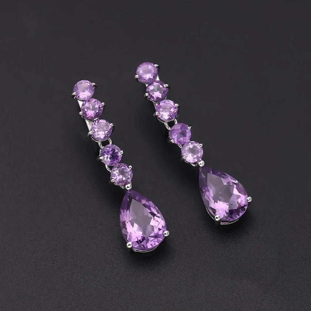 Sterling silver drop earrings with a vertical line of round amethyst stones and teardrop-shaped violet gemstones