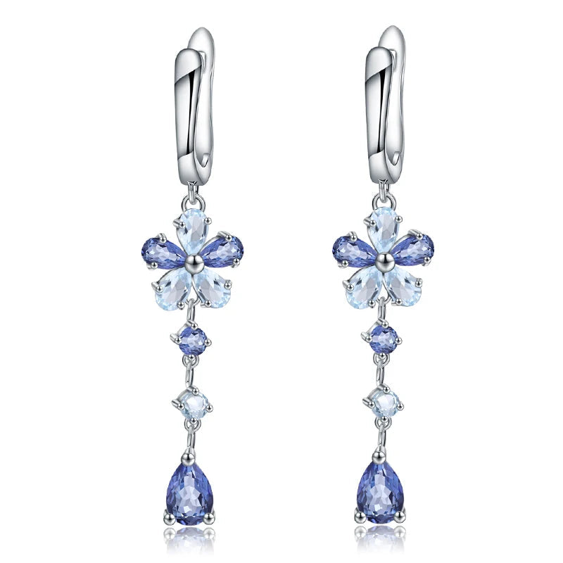 Drop earrings featuring floral blue gemstone clusters and pear-cut drops on a silver setting