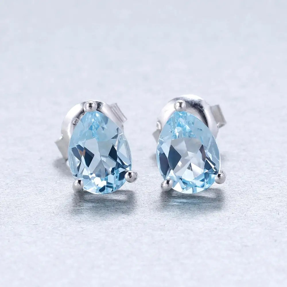 Sterling silver stud earrings with pear-shaped blue topaz gemstones in a three-prong setting