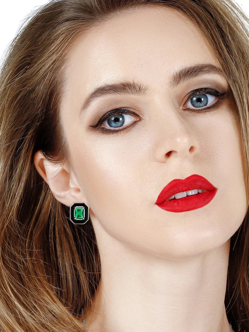 Silver earrings with black enamel octagonal frames and green emerald-cut stones at the center