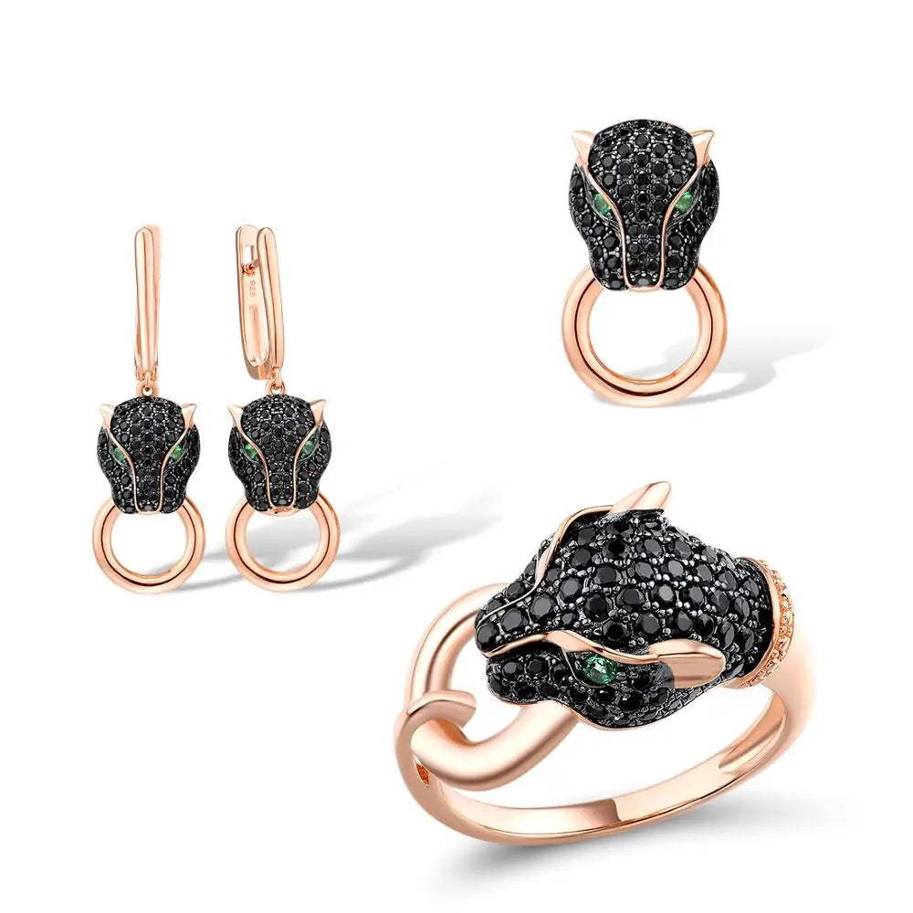 Rose gold jewelry set with panther head designs featuring black stones and green eyes, including earrings, ring, and pendant.