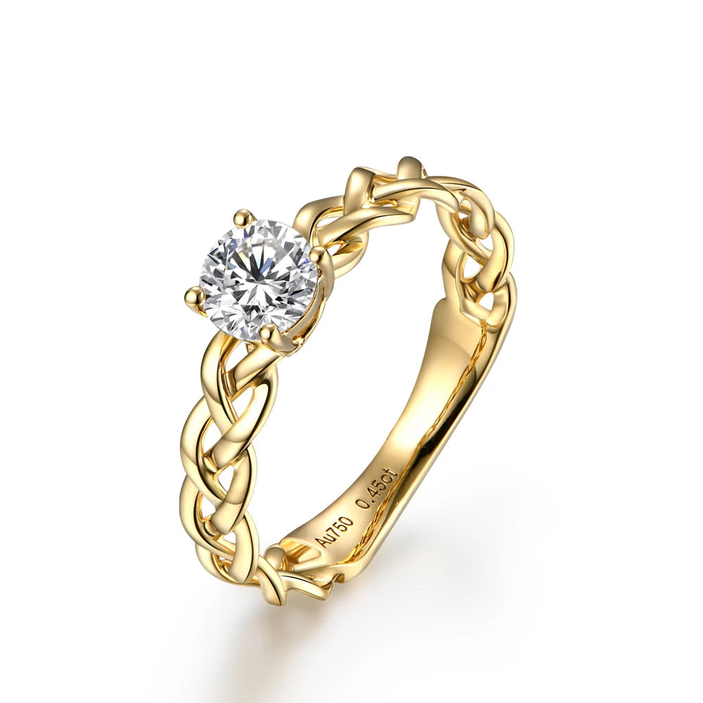 Gold ring with a braided band design and a round-cut clear central stone in a four-prong setting.
